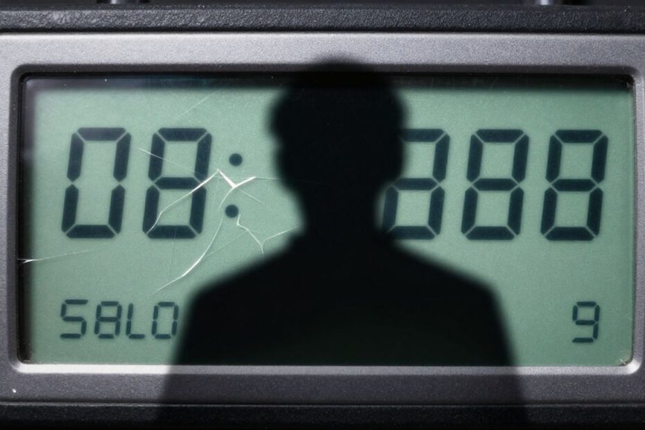 Cracked digital lock with shadowy figure, cybersecurity breach.